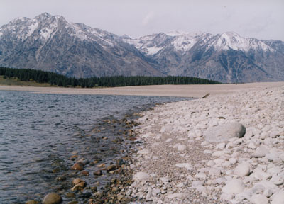 Photo at the edge of the water with mountains in the backgound